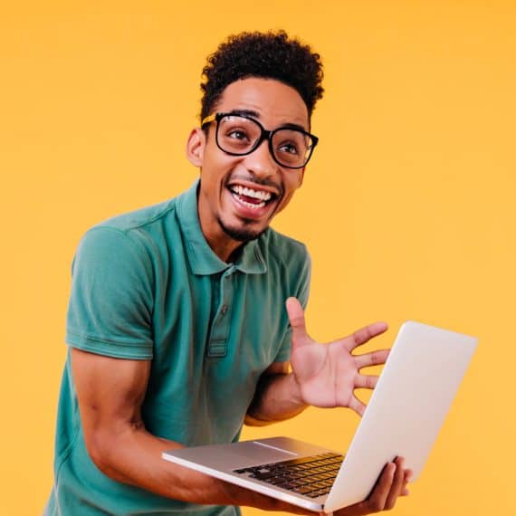 laughing-black-man-glasses-expressing-excitement-emotional-international-student-holding-computer